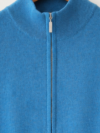 Blue zip-up sweater on a wooden hanger against a white background